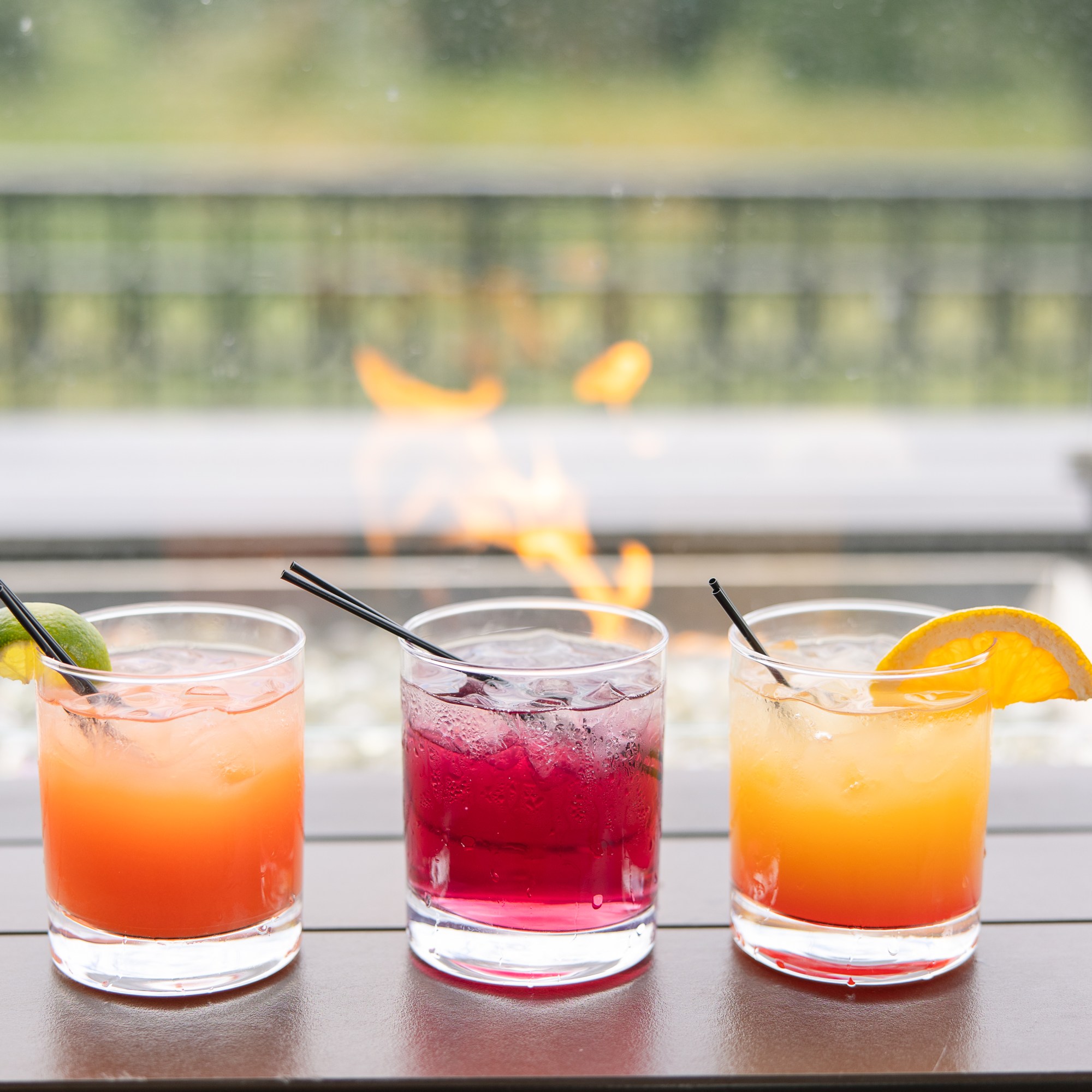 Three different cocktails sat in front of a firepit at The Hill Tavern Bar & Grill at Galloping Hill Golf Course in Kenilworth, NJ.
